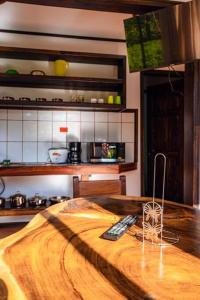 a kitchen with a wooden table with two remote controls at Venus in Montezuma
