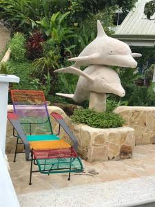 two chairs and a dolphin statue in front of a fountain at Venus in Montezuma