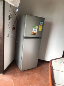 a stainless steel refrigerator in a kitchen next to a wall at Venus in Montezuma