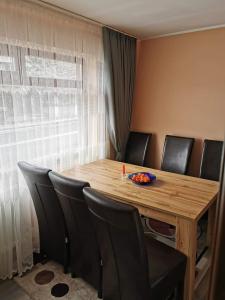 a dining room table with black chairs and a wooden table at Katarina Central House Predeal in Predeal