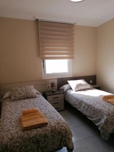 - une chambre avec 2 lits et une fenêtre dans l'établissement Casa IRIENSE VUT-CO-004308, à Padrón