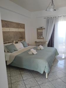een slaapkamer met een groot bed en 2 handdoeken bij Manganas Studios in Paleokastritsa