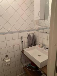 a white bathroom with a sink and a mirror at Tonnila, big villa for 10-Person at Turku near Meyer gate in Turku