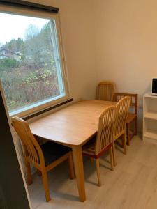 a wooden table and chairs in a room with a window at Omakotitalo, Perno (near Meyer gate) in Turku