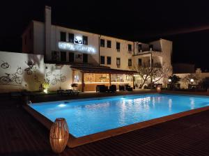 uma piscina em frente a um hotel à noite em Hotel Boavista - Vintage House em Monfortinho