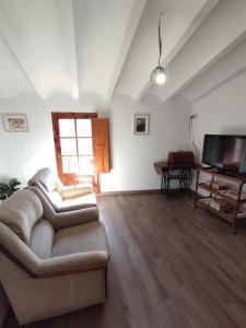 a living room with a couch and a television at CASA DALMA in Ballestar