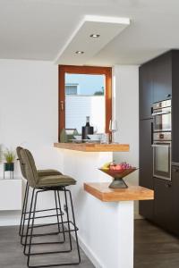 a kitchen with a counter with a chair and a bowl of fruit at Nord29 - Exklusive Ferienwohnung am Waldrand Meschede in Meschede