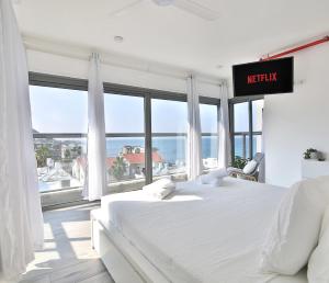 een slaapkamer met een bed en een groot raam bij Bat-Galim Beach Apartment in Haifa