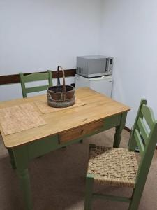 a wooden table with a microwave and two chairs at Mykonos Centro Apartamento in Carmelo