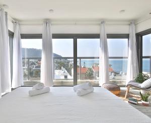 een slaapkamer met een groot bed en 2 handdoeken bij Bat-Galim Beach Apartment in Haifa
