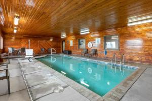 a large swimming pool in a building with a wooden ceiling at Clarion Inn Kingman I-40 Route 66 in Kingman