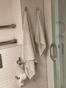 uma casa de banho com toalhas penduradas na porta do chuveiro em Modern Apartment suitable for longstays em Riga