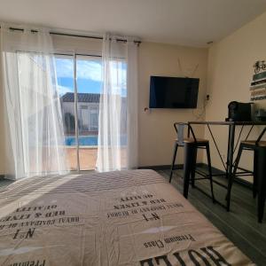 Televízia a/alebo spoločenská miestnosť v ubytovaní Chambre avec piscine partagée