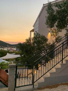 a set of stairs next to a house with a sunset at Apartman Vitanov in Vinišće