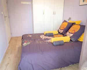 - une chambre avec un grand lit et des oreillers jaunes dans l'établissement Le Monplaisir - T2 Cosy - Proche du métro, à Lyon