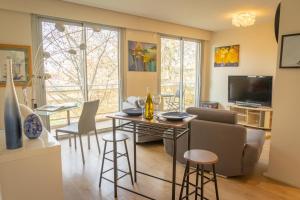 een woonkamer met een bank en een tafel en stoelen bij Le Monplaisir - T2 Cosy - Proche du métro in Lyon