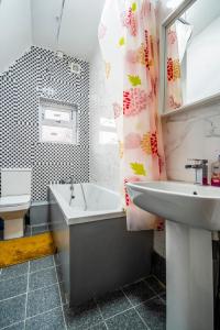 a bathroom with a sink and a bath tub and a sink at Deluxe 2-Bedroom Flat with Free parking in Birmingham