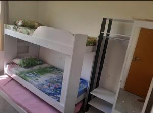 two bunk beds in a room with a mirror at Apto PDI na praia em Baixio in Baixio