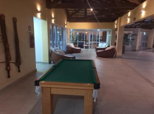 a pool table in the middle of a room with couches at Apto PDI na praia em Baixio in Baixio