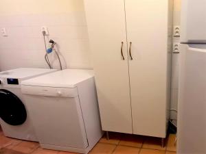 lavadero con lavadora y nevera en l'Ecurie - La Maïsou, en Sérignac