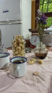 einen Tisch mit einer Tasse Kaffee und einer Vase Blumen in der Unterkunft Miraflores Casa de Campo in San Salvador de Jujuy
