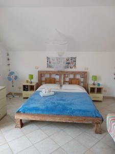 a bedroom with a large bed with a blue blanket at Santa Maria flats in Santa Maria