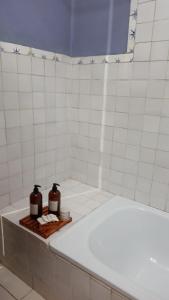 y baño con bañera y 2 botellas de jabón. en Miraflores Casa de Campo en San Salvador de Jujuy