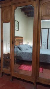 a bedroom with a bed and a large mirror at Miraflores Casa de Campo in San Salvador de Jujuy