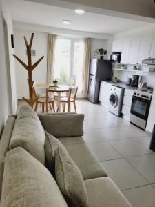 Una sala de estar con un sofá y una cocina. en Departamento Altos de Ushuaia, en Ushuaia