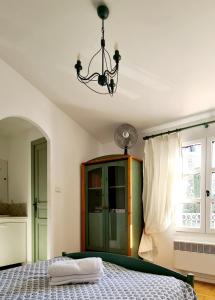 a bedroom with a bed and a chandelier at HAMEAU DES AMANDIERS - vue mer, golf et vignes in Saint-Cyr-sur-Mer