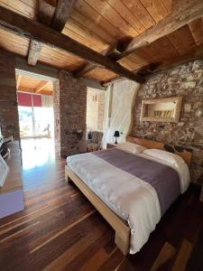 um quarto com uma cama grande numa parede de pedra em LA CASETTA NEI COLLI em Bérgamo