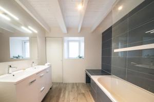 ein Badezimmer mit einer Badewanne, einem Waschbecken und einem Badetubermott in der Unterkunft AR PENNITI - Magnifique maison en pierre proche plage in Landéda