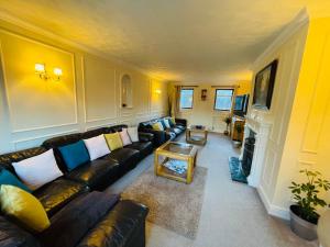 a living room with a couch and a fireplace at Super King Bed Suite, Executive office, fast WiFi, free parking in St. Ives