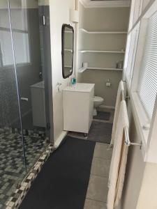 a bathroom with a shower and a sink and a mirror at Arbeidsgenot, Unit 2 in Herolds Bay +9 photos