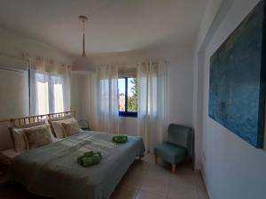 a bedroom with a bed and a green chair at Marina Gardens in Paphos