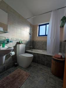 uma casa de banho com um WC, um lavatório e uma banheira em Marina Gardens em Pafos