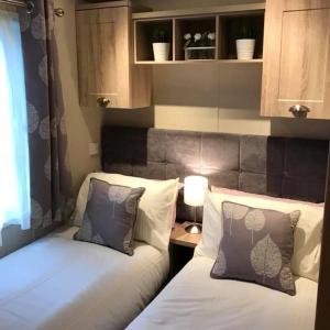 two beds sitting next to each other in a room at Lemon Tree Lodge in Morpeth