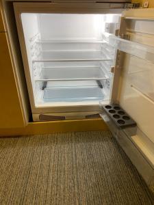 an empty refrigerator with its door open in a room at Rooms Kokhta-Mitarbi apartments in Bakuriani