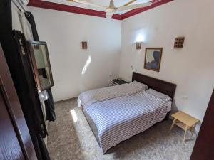 a small bedroom with a bed and a chair at Nile Panorama Hotel in Luxor