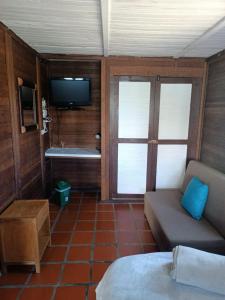 um quarto com um sofá e uma televisão num quarto em Cabañas Navegar- El peñol, Guatape em Guatapé