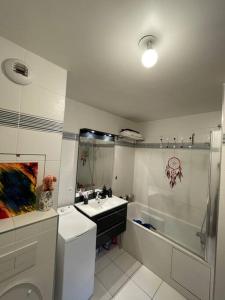 a bathroom with a sink and a toilet and a shower at Luxury & Cosy apart with balcony Eiffel Tower view in Issy-les-Moulineaux