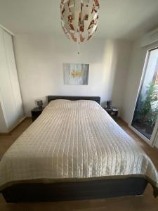 een slaapkamer met een bed met een wit dekbed bij Luxury & Cosy apart with balcony Eiffel Tower view in Issy-les-Moulineaux