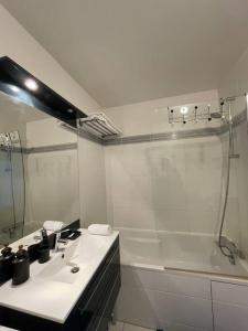 een witte badkamer met een wastafel en een douche bij Luxury & Cosy apart with balcony Eiffel Tower view in Issy-les-Moulineaux