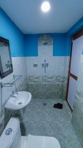 a bathroom with a white toilet and a sink at Patlekhet Eco Farmhouse in Dhulikhel