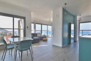 a kitchen and living room with a table and chairs at Bat-Galim Beach Apartment in Haifa