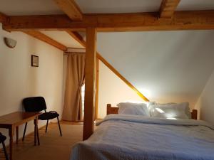 ein Schlafzimmer mit einem Bett, einem Tisch und einem Stuhl in der Unterkunft Casa Victoria in Moieciu de Sus