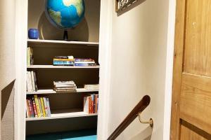a room with a book shelf with a globe on it at Charming 1 bed loft in 16C house in city centre in Norwich