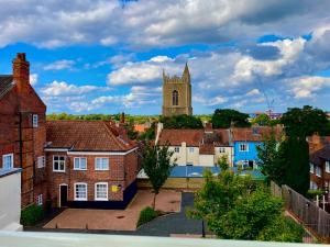 Blick auf eine Stadt mit einer Kirche im Hintergrund in der Unterkunft Charming 1 bed loft in 16C house in city centre in Norwich