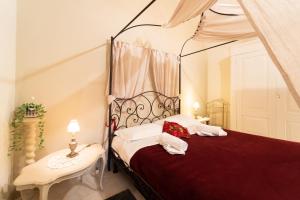 a bedroom with a red and white bed and a table at RESIDENZA ALDROVANDI SUITE in Bologna