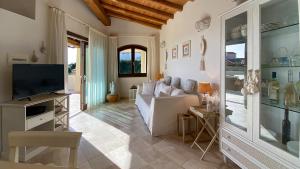 sala de estar con sofá y TV en Villa Dalia Punta Molara San Teodoro en San Teodoro